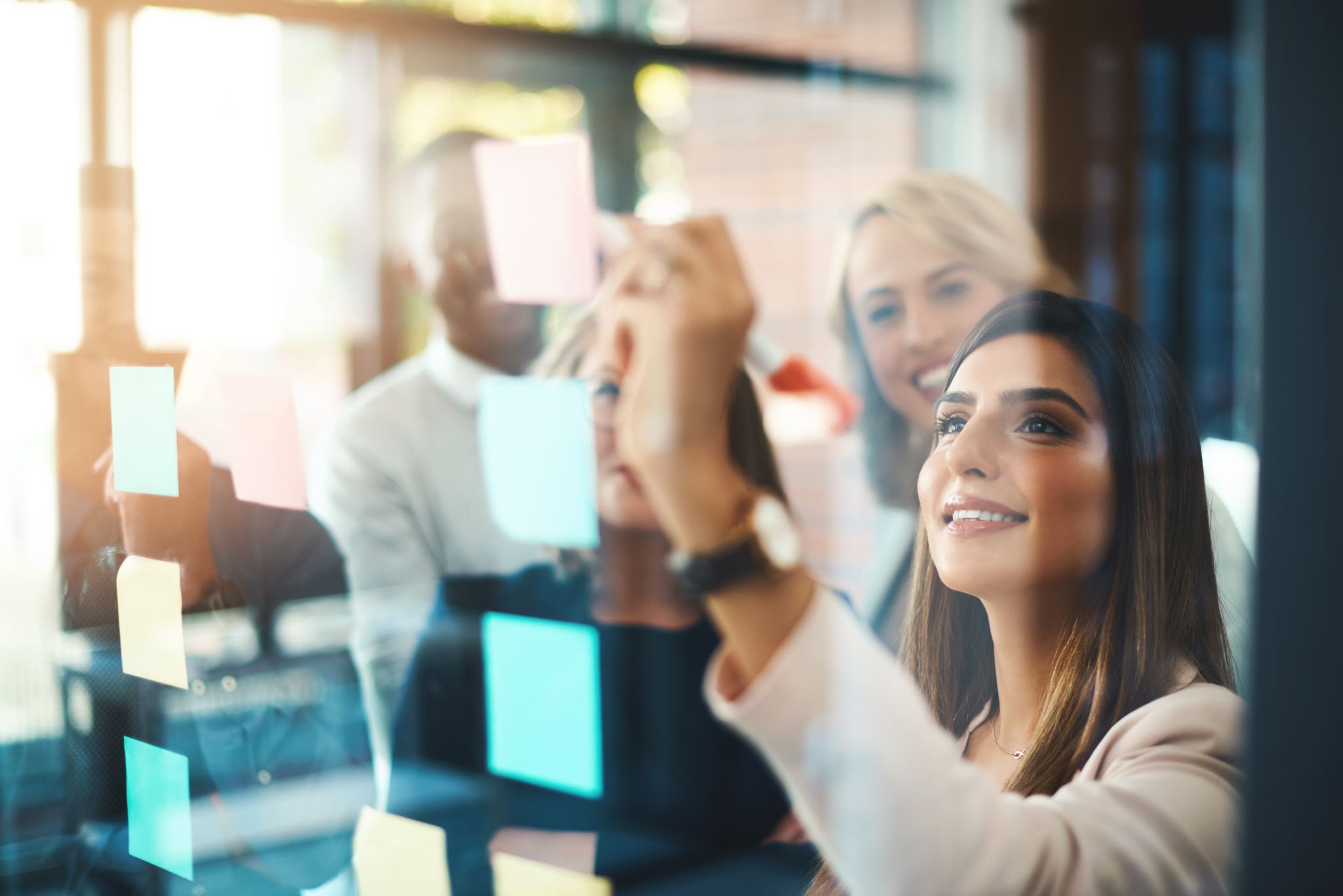 Businesswomen-writing-on-glass-in-meeting