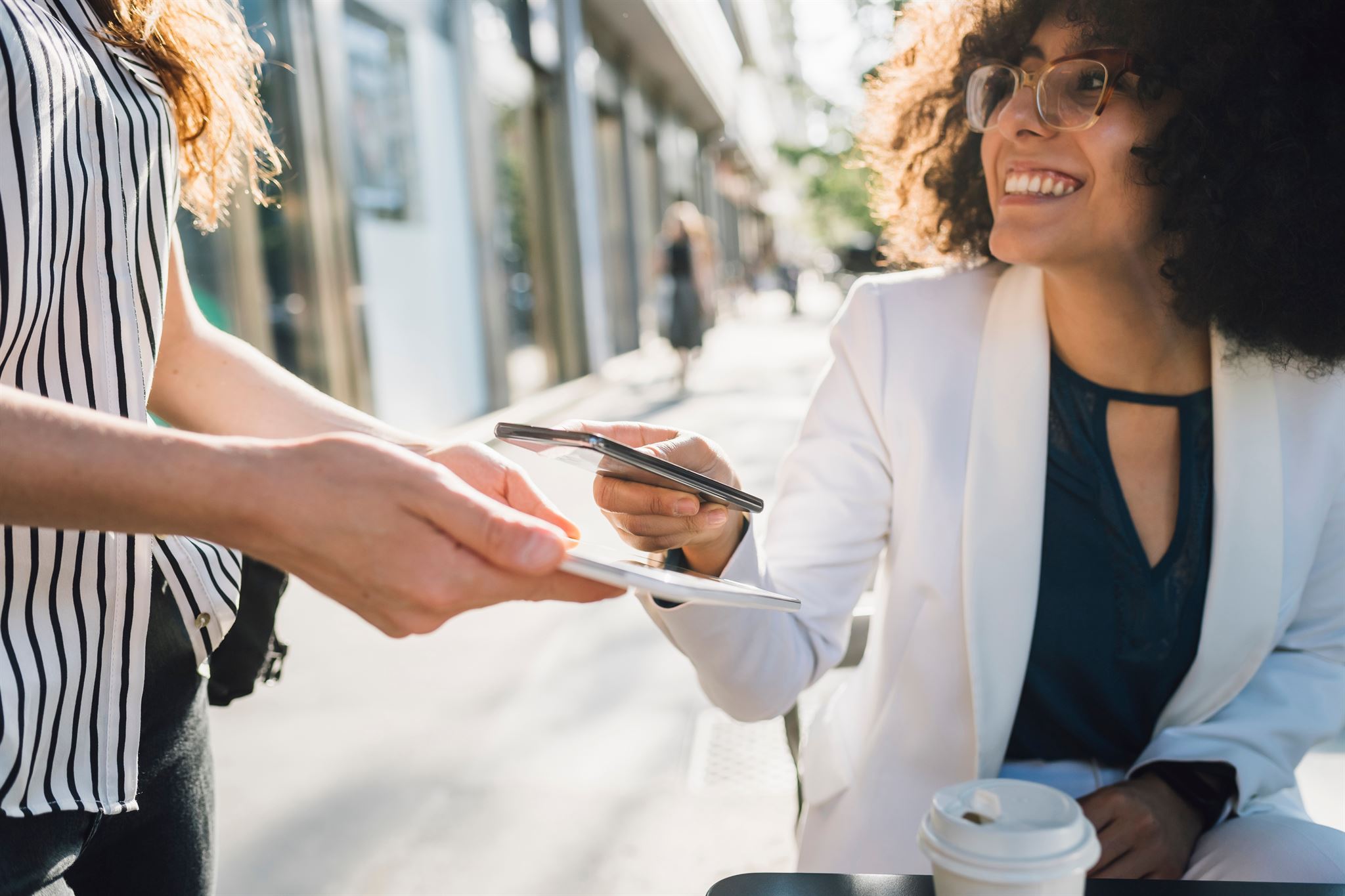 Woman-purchasing-coffee-with-cellphone